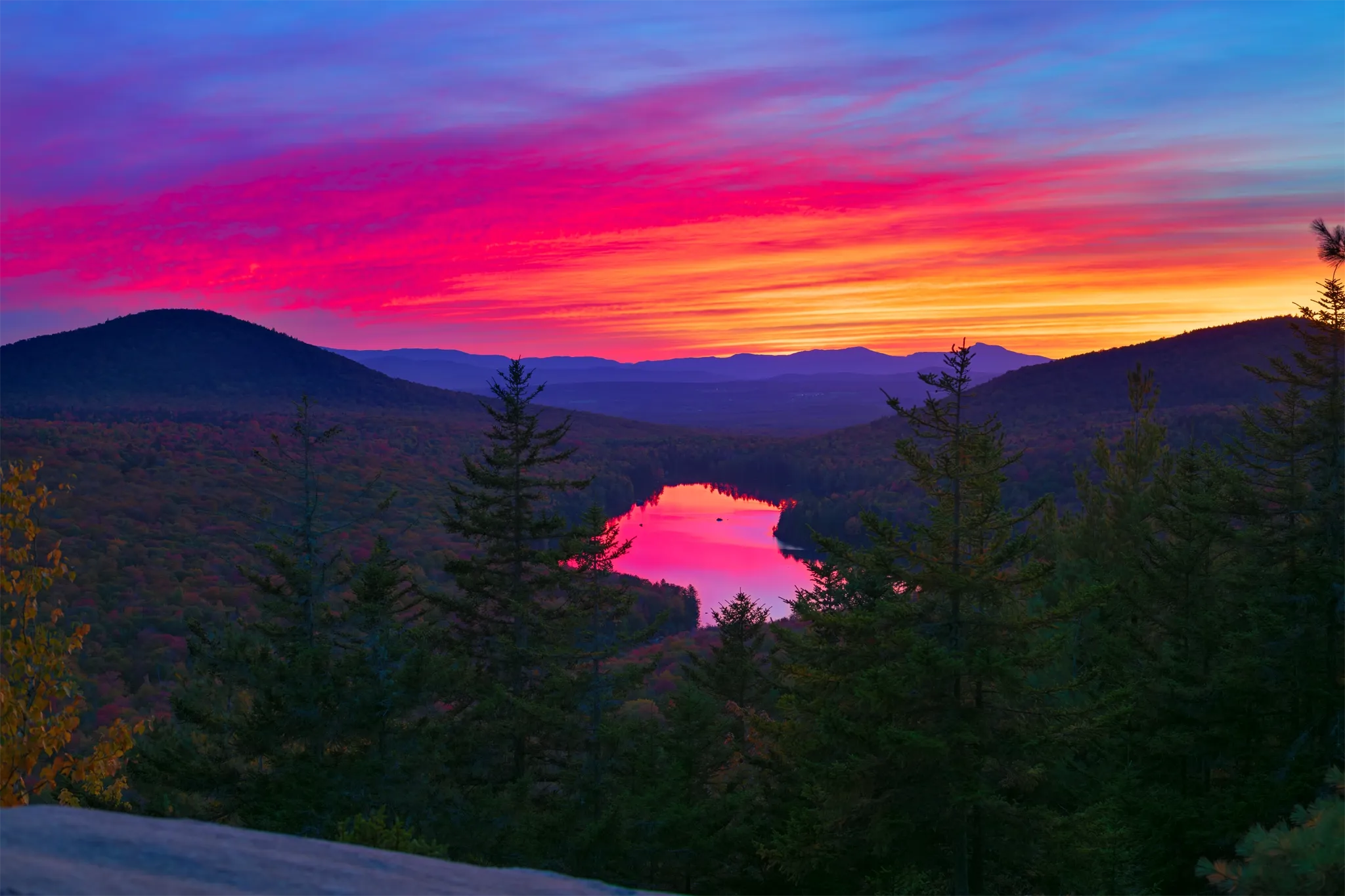 A view of Magenta Awakening Over Kettle Pond: Owls Head Mountain in Groton State Forest, VT on the Owls Head Mountain Trail at sunset in Autumn.